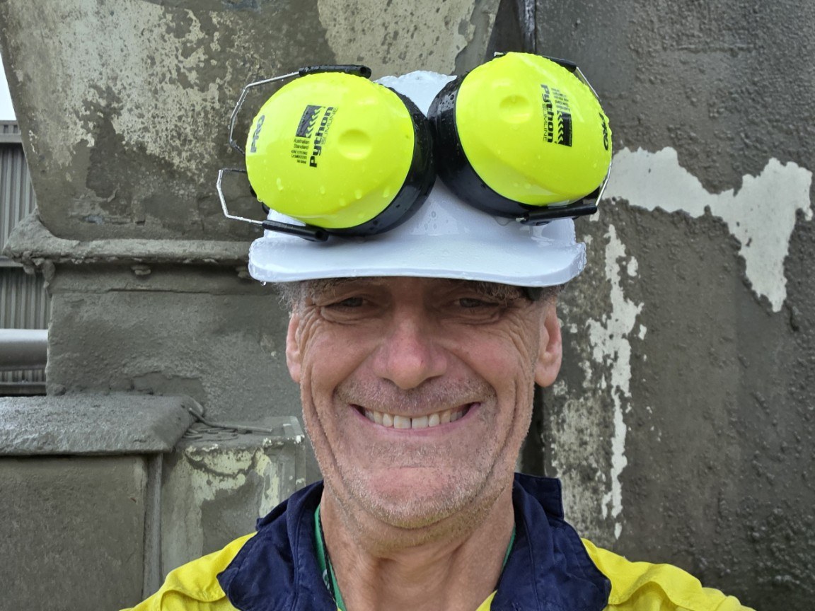 Brett Hawthorne on site in operational PPE against a weathered concrete infrastructure backdrop